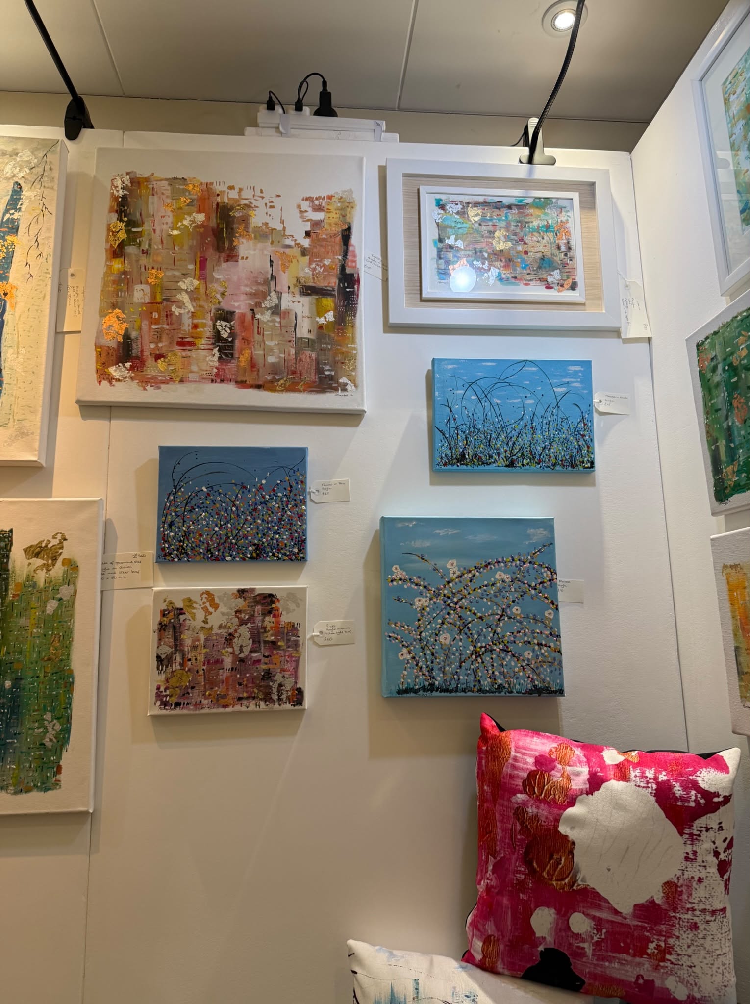 Alice Chambers exhibition showing blue and teal abstract paintings with cushions and framed works